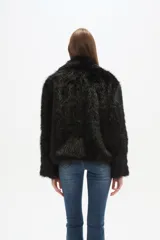 Campera de piel sintética color negro, con cuello, manga larga y cierre frontal. Presenta un diseño de corte holgado y textura suave.