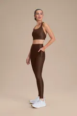 Top deportivo de compresión media con diseño de espalda cruzada y breteles finos. Confeccionado en tejido acanalado con un acabado de brillo sutil, cuenta con copas removibles y tecnología de ajuste adaptable.