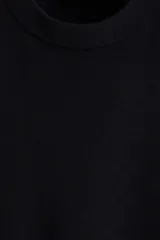 Buzo negro de punto fino de lana merino, con cuello redondo y remates acanalados en cuello, puños y bajo. Corte estándar.