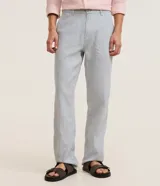 Pantalón de lino color gris claro, de corte recto, con trabillas en la cintura, cierre tradicional y bolsillos laterales.