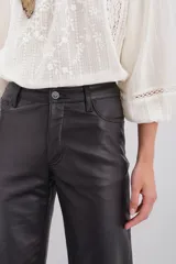 Pantalón de cuero ovino con corte oxford y tiro medio. Presenta diseño de cinco bolsillos, cierre frontal con botón metálico y costuras horizontales a la altura de la rodilla.