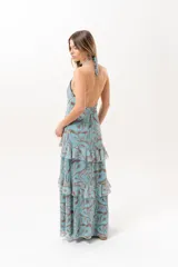 Vestido largo celeste con estampado abstracto en tonos marrones, escote halter con abertura en el frente y volados escalonados en la falda.