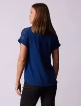 Remera combinada blanca, marca Rio & Rian, con cuello a la base y mangas cortas con aplique calado y broderie.