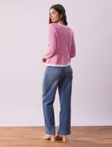 Cardigan de tejido tweed celeste y blanco, con escote redondo, cierre frontal con botones metálicos dorados y bolsillos simulados en el frente.