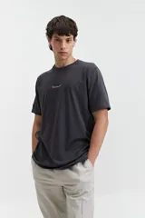 Remera de manga corta color gris oscuro, con estampado frontal de la palabra "Unlimited" en blanco y un pequeño detalle de etiqueta en la manga izquierda.