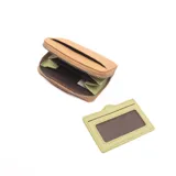 Monedero pequeño color camel con cierre de cremallera y bolsillo externo para tarjetas en color verde claro.