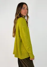 Sweater de punto con cuello alto, manga larga y puños acanalados. Presenta un diseño de corte holgado y tejido suave.