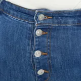 Pantalón de jean skinny azul con cinco bolsillos y cierre frontal con botones.