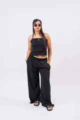 Pantalón palazzo negro de corte wide leg, confeccionado en tela ligera con caída y cintura elastizada de tiro medio-alto.