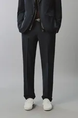Pantalón de traje regular fit negro, confeccionado en tejido técnico transpirable Non Iron, con bolsillos frontales, bolsillos traseros de vivo y cierre frontal con cremallera y botón.