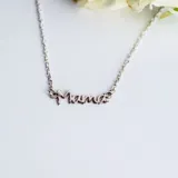 Collar de plata 925 con dije de nombre en cursiva que dice 'Mamá', sujeto a una cadena de eslabones finos.