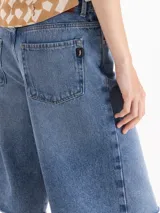 Bermuda de tiro medio/alto y calce recto, confeccionada en denim de algodón con lavado azul medio. Presenta amplitud hacia la bota, calce holgado, largo a la rodilla y ruedo deshilachado al corte.