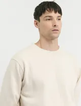 Sweater básico de cuello redondo y manga larga, confeccionado en tejido circular con puños y cuello en tejido canalé.