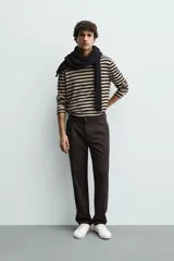 Pantalón de corte recto confeccionado en tejido elástico, con cintura elástica, pliegues frontales, bolsillos laterales y bolsillos traseros de vivo con botón.