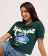Remera verde oscuro de algodón con cuello redondo y mangas cortas. Estampado frontal con el personaje de Stitch y la frase "Time to Chill Lazy Weekends".