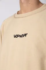 Buzo de cuello redondo confeccionado en tejido rústico con bordes al corte y costuras expuestas. Presenta un diseño boxy con estampado frontal y es reversible, permitiendo su uso por ambos lados.