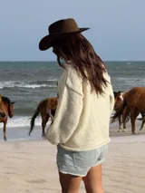 Sweater tejido a mano en lana merino virgen sin teñir, con letras bordadas a mano en tono azul marino y chocolate. Diseño unisex y calce relajado.