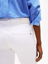 Pantalón jean blanco de corte bootcut y tiro medio, confeccionado en tejido denim elástico de algodón. Cuenta con cierre de cremallera con botón, cinco bolsillos, detalles distintivos de la marca y logo bordado en el bolsillo trasero.