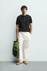 Camiseta de manga corta con cuello panadero y cierre frontal de tres botones. Presenta una textura acanalada y un corte regular fit.