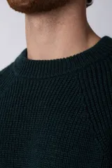Sweater negro de tejido grueso con cuello redondo y corte relajado.