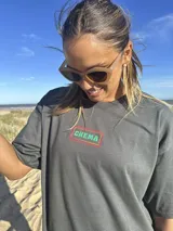 Remera color crema de algodón con estampa en la espalda de un paisaje playero con el texto "Chema Sure Chate et la mer".