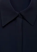 Vestido midi de corte evasé en color azul marino, con cuello camisero, cierre frontal de botones ocultos y mangas largas con puños abotonados. Incluye un cinturón fino ajustable con hebilla metálica.