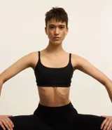 Top deportivo femenino color morado oscuro, de corte recto y ajustado, con escote cuadrado y breteles finos ajustables.