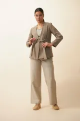 Chaqueta corta color beige, entallada, con escote en V, manga larga y bolsillos escondidos. Cierre frontal con lazo fijo. Confeccionada en lana fina sin teñir. Diseño exclusivo de Don Baez.