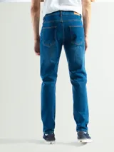 Jean de hombre, color negro, de corte regular y largo estándar. Presenta cierre frontal con botón y bolsillos clásicos.