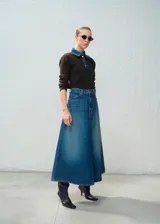 Falda larga de denim azul, corte evasé y tiro alto, con costuras pespuntadas y diseño clásico de cinco bolsillos.