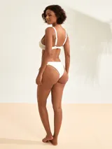 Bombacha de bikini colaless blanca con tiras laterales ajustables decoradas con cuentas de carey y herrajes dorados.