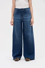 Jean de corte wide leg con tiro medio, confeccionado en denim azul clásico. Presenta un diseño holgado desde la cadera hasta el bajo, con pierna ancha y relajada.