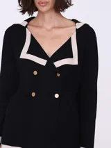 Cárdigan color beige con cuello marinero con borde gris, doble botonadura dorada y mangas largas. Tejido de punto.