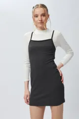 Vestido corto al cuerpo a cuadrillé blanco y negro, con cuello alto y mangas cortas.