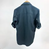 Camisa de manga larga verde petróleo con cuello italiano y logo bordado en el pecho.