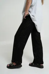 Pantalón negro de tejido calado con cintura elástica.