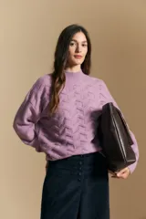 Sweater de punto color beige con diseño geométrico en relieve, cuello alto y mangas largas con puños acanalados.