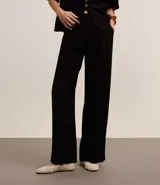 Pantalón de vestir de corte palazzo color negro, con cintura alta, trabillas, cierre tradicional y pliegues.