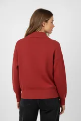 Sweater de tejido punto color marrón, con cuello polo y cierre frontal parcial, de manga larga y diseño holgado.