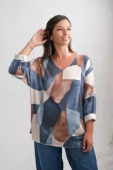 Sweter de punto amplio con escote en V y manga larga, presenta un diseño estampado con bloques geométricos en tonos azul, marrón y beige.