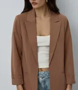 Blazer de sastrería color bordó, de corte oversized y largo, confeccionado en crepé. Presenta solapas clásicas, bolsillos frontales y detalle de pliegues en los puños.