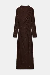 Vestido midi de manga larga, color marrón oscuro, confeccionado en tejido de encaje o punto con patrón floral sutil. Presenta cuello perkins y drapeado asimétrico en el torso con frunces laterales.