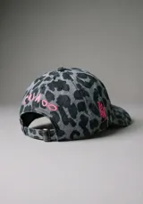 Gorra de béisbol con estampado animal print en tonos azules y grises, y bordado blanco en el frente. Cuenta con visera curva y ajuste regulable en la parte trasera.