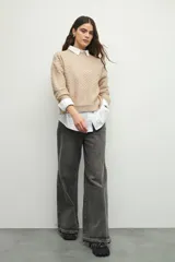 Sweater de punto con textura en relieve, cuello redondo y mangas largas con puños ajustados.