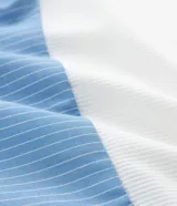 Vestido midi de la marca Ashua con parte superior de malla lisa en color blanco y falda de algodón con estampado de rayas verticales en azul y blanco. Posee mangas cortas, escote redondo y un lazo ajustable en la cintura.