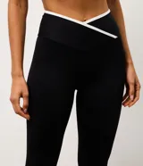Pantalón deportivo tipo legging de la marca Get Over, confeccionado en microfibra elástica con cintura cruzada y detalle de viés contrastante.