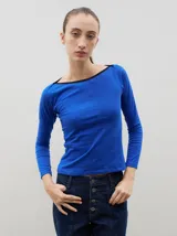 Remera de manga larga color azul con escote bote y detalle de borde en color negro. Presenta un ajuste al cuerpo.