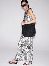 Mono largo de viscosa color blanco con estampado de flores y hojas en negro. Tiene breteles finos, corte amplio y bolsillos laterales.