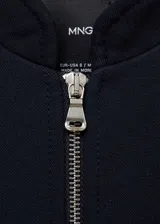 Chaqueta tipo bomber de color negro con cuello redondo y cierre frontal con cremallera metálica. Presenta un diseño recto de manga larga y cuenta con forro interior.