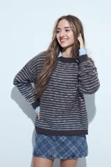 Sweater de tejido de punto con diseño de rayas horizontales en tonos bordó y celeste. Presenta cuello redondo, corte holgado y mangas largas con puños ajustados.